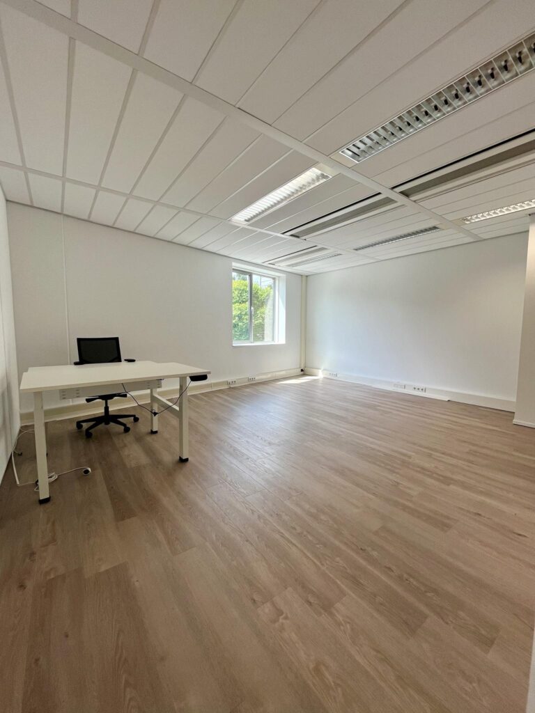 Minimalist office space with a single desk and chair at Koningin Wilhelminaplein.